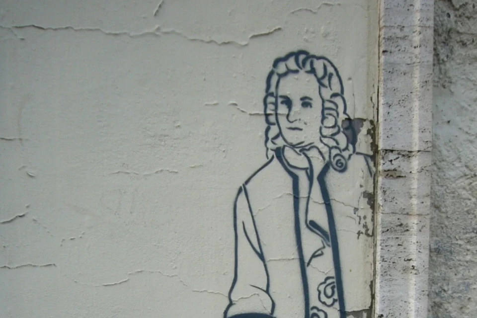 Eine Zeichnung von Bach auf einer grauen Wand.