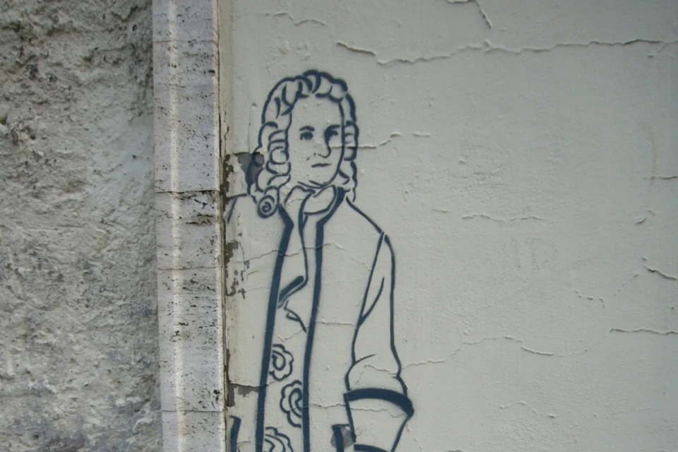 Eine Zeichnung von Bach auf einer grauen Wand.