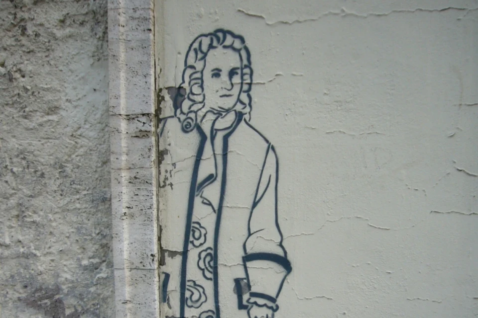 Eine Zeichnung von Bach auf einer grauen Wand.