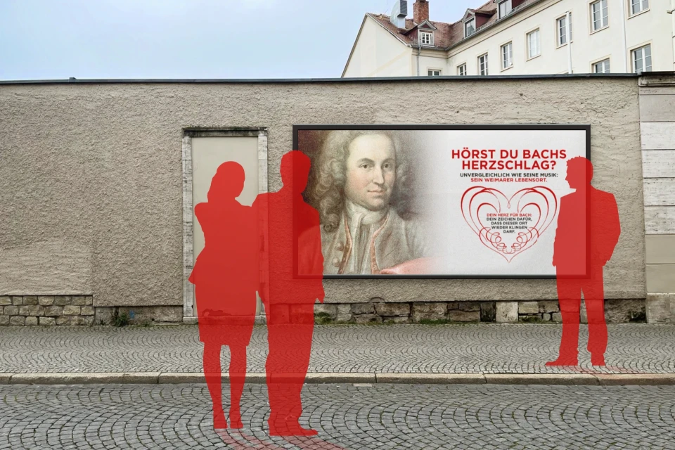 Ein Plakat an einer Mauer in Weimar. Davor sind stilisierte Personen zu erkennen.
